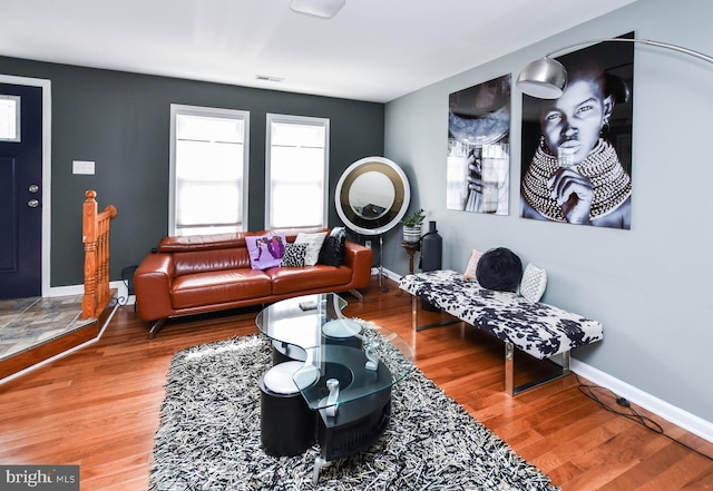 living area with visible vents, baseboards, and wood finished floors