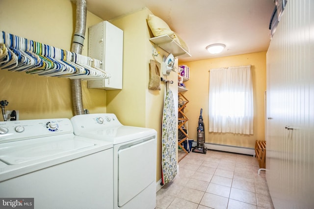 washroom featuring a baseboard heating unit, washer and clothes dryer, light tile patterned flooring, and cabinet space