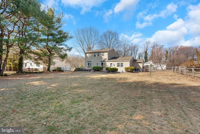 exterior space featuring a chimney, fence, and a yard