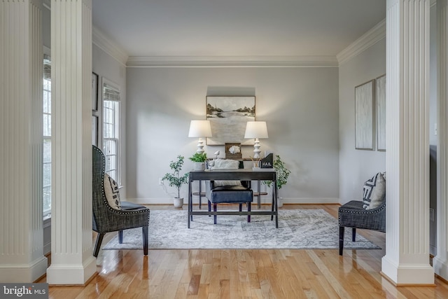 sitting room with ornate columns, crown molding, baseboards, and wood finished floors