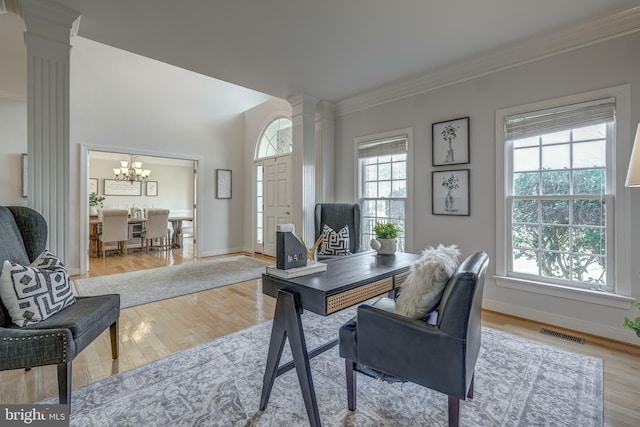 office featuring ornamental molding, visible vents, decorative columns, and light wood finished floors