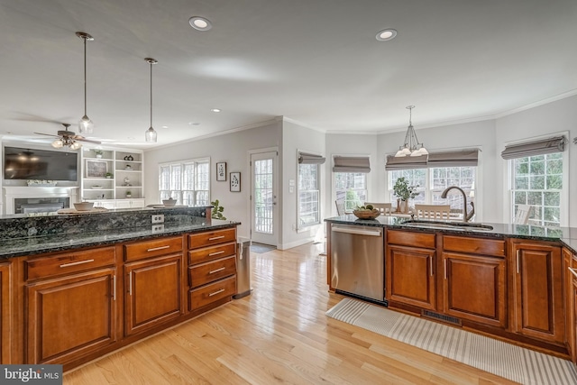 kitchen featuring dishwasher, brown cabinetry, a sink, and light wood-style flooring