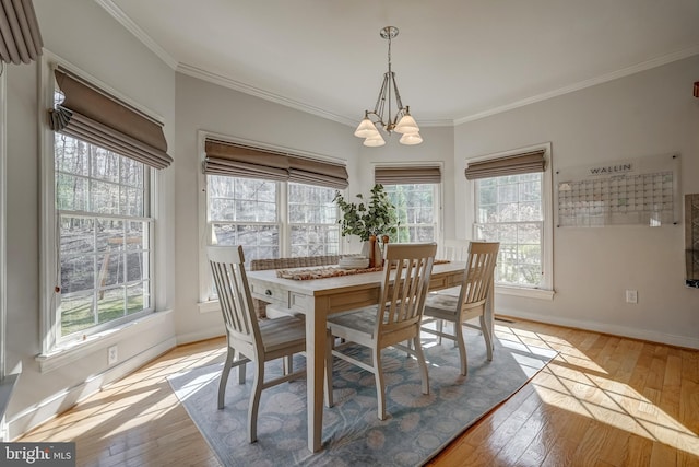 dining area with light wood finished floors, baseboards, and a notable chandelier