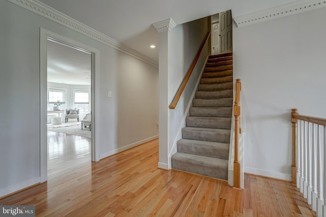 stairway featuring ornamental molding, recessed lighting, wood finished floors, and baseboards