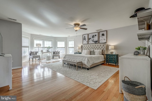 bedroom with light wood finished floors, multiple windows, and visible vents