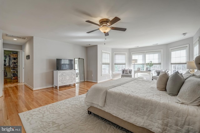 bedroom with baseboards, visible vents, ceiling fan, and light wood finished floors