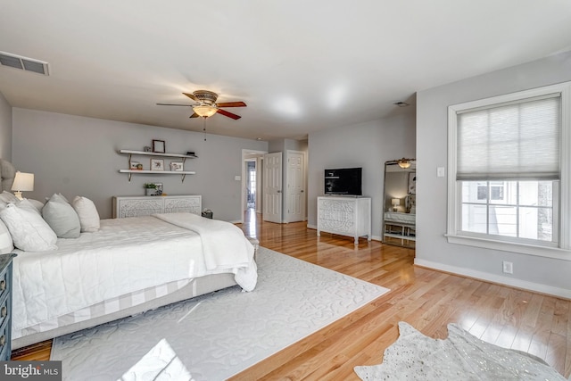 bedroom featuring a ceiling fan, baseboards, visible vents, and light wood finished floors