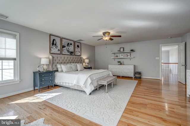 bedroom with ceiling fan, light wood-type flooring, visible vents, and baseboards