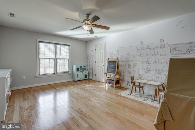 unfurnished room with light wood finished floors, baseboards, visible vents, and a ceiling fan