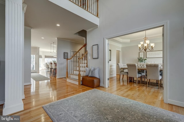 entrance foyer with a chandelier, baseboards, ornamental molding, stairway, and hardwood / wood-style floors