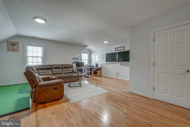 living area with lofted ceiling, baseboards, and wood finished floors