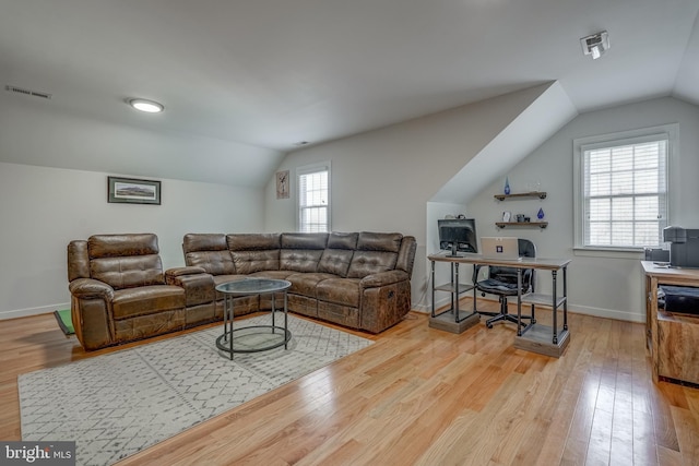 living area with vaulted ceiling, hardwood / wood-style floors, visible vents, and baseboards