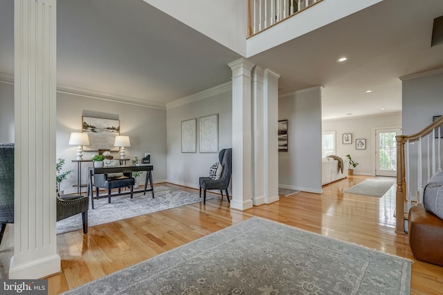 interior space with decorative columns, baseboards, stairway, wood finished floors, and crown molding