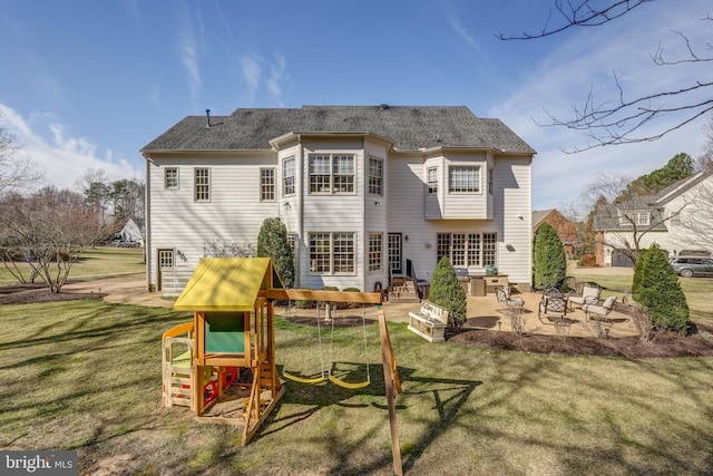 rear view of property featuring a patio area, a shingled roof, a playground, and a yard