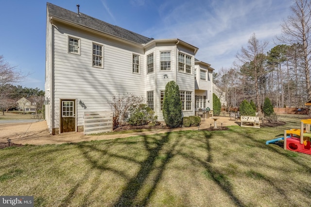 rear view of house with a patio area and a lawn