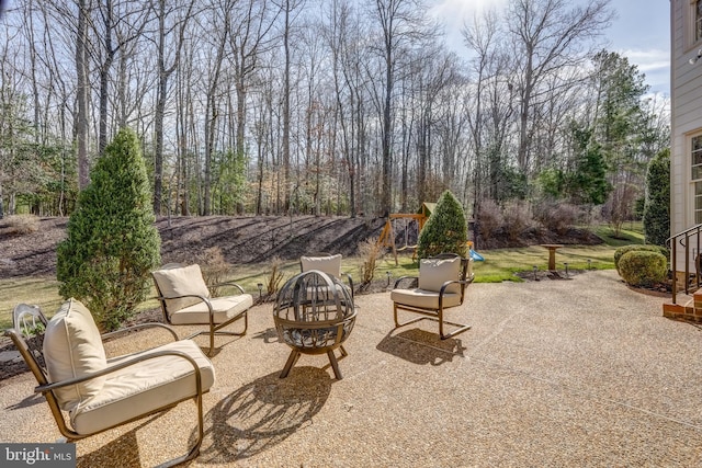 view of patio / terrace with a fire pit and a playground