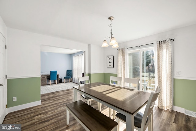 dining room featuring an inviting chandelier, baseboards, and wood finished floors