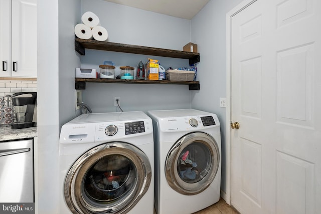 clothes washing area with laundry area, light tile patterned flooring, and washer and dryer