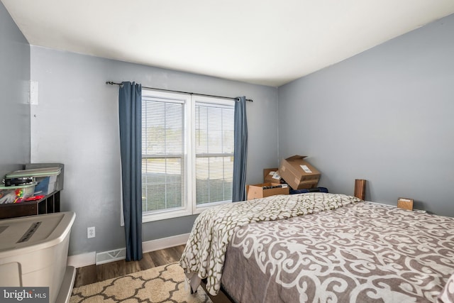 bedroom featuring wood finished floors, visible vents, and baseboards