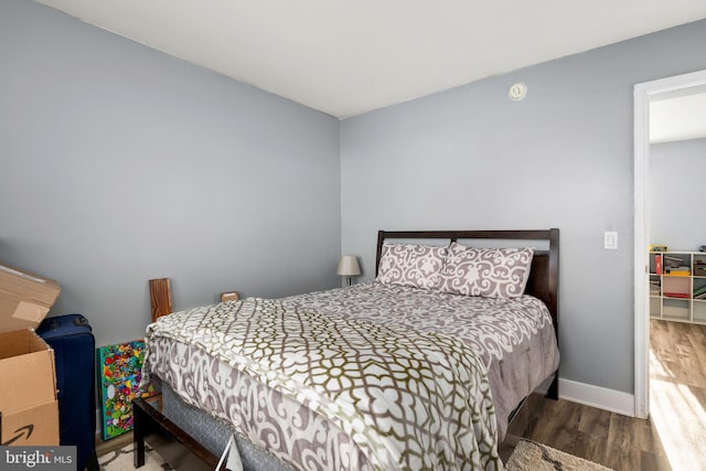 bedroom with baseboards and wood finished floors