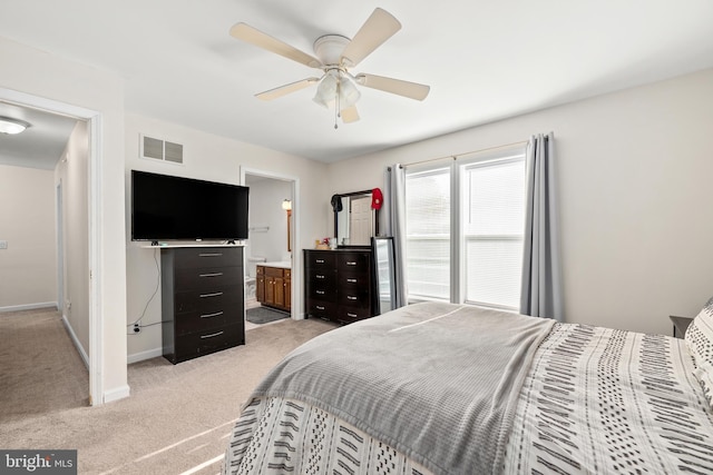 bedroom featuring baseboards, visible vents, connected bathroom, light colored carpet, and ceiling fan