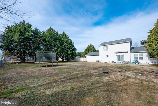 view of yard featuring a trampoline, a patio area, and a fenced backyard