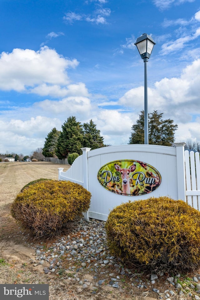 community / neighborhood sign with fence