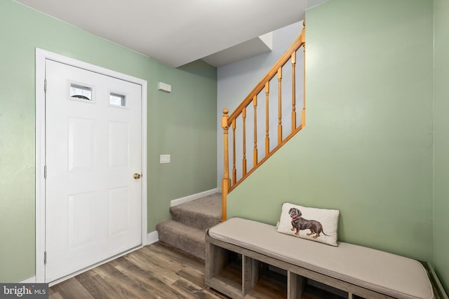 foyer entrance with stairway, baseboards, and wood finished floors