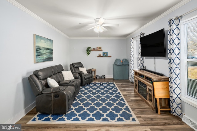 living area featuring visible vents, crown molding, baseboards, and wood finished floors