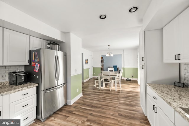 kitchen featuring white cabinetry, wood finished floors, and freestanding refrigerator