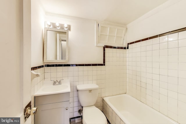 bathroom with toilet, a bathtub, tile walls, and vanity