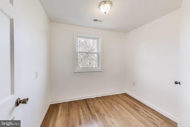 unfurnished room featuring light wood-style flooring, visible vents, and baseboards