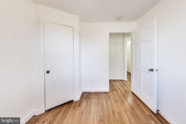 unfurnished bedroom featuring light wood-type flooring and baseboards