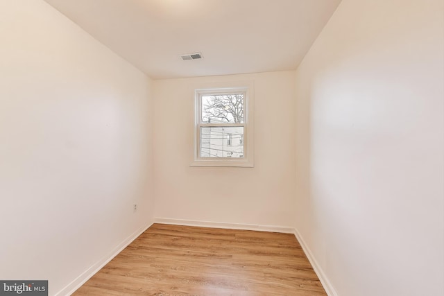 unfurnished room with baseboards, visible vents, and light wood finished floors