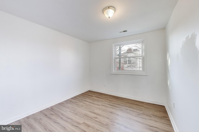 unfurnished room featuring visible vents, baseboards, and wood finished floors