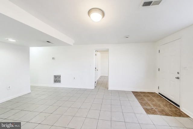 unfurnished room featuring light tile patterned floors, visible vents, and baseboards