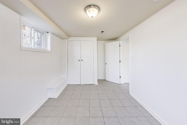 unfurnished bedroom with a closet, visible vents, baseboards, and light tile patterned floors