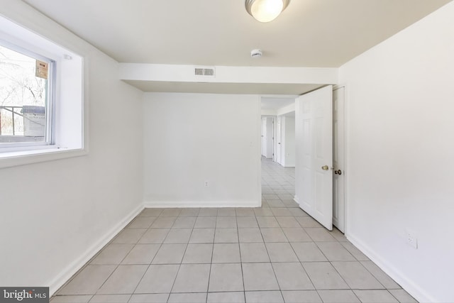 spare room with light tile patterned flooring, visible vents, and baseboards