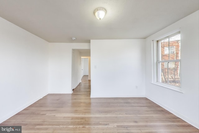 unfurnished room featuring light wood-type flooring and baseboards