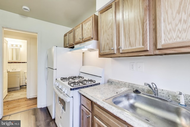 kitchen with white range with gas cooktop, decorative backsplash, dark wood-style flooring, under cabinet range hood, and a sink