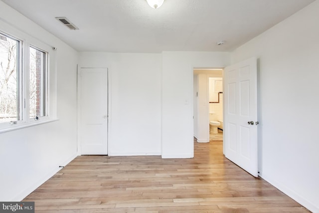 unfurnished bedroom with light wood-style floors, baseboards, and visible vents