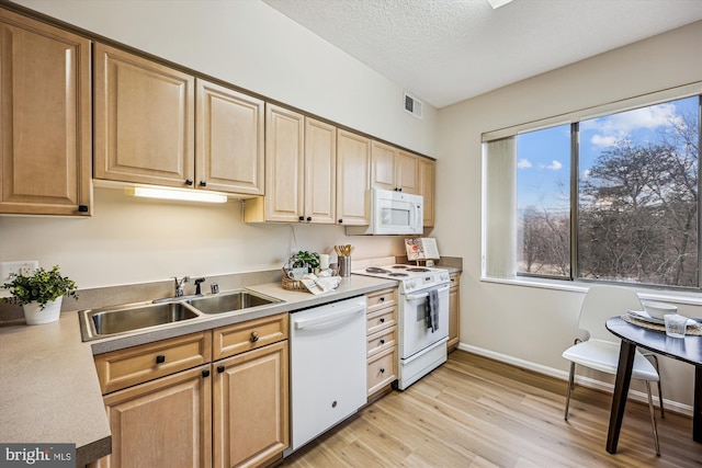 kitchen featuring white appliances, baseboards, visible vents, light wood-type flooring, and a sink