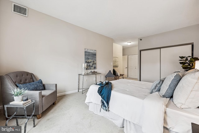 carpeted bedroom featuring a closet, visible vents, and baseboards