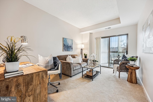 living area with visible vents, light carpet, baseboards, and a textured ceiling