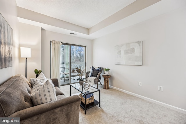 carpeted living area with visible vents, a textured ceiling, and baseboards