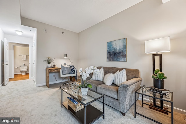 carpeted living area featuring baseboards