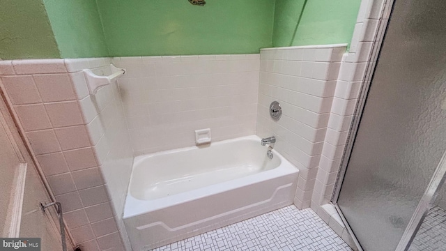 bathroom featuring tile patterned flooring, a washtub, a shower, and tile walls