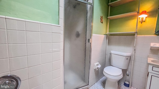 bathroom featuring a stall shower, wainscoting, tile patterned flooring, and toilet