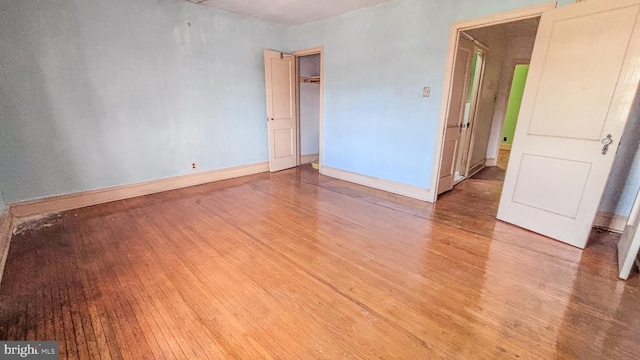 empty room featuring light wood finished floors and baseboards