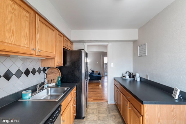 kitchen featuring tasteful backsplash, dark countertops, a sink, and appliances with stainless steel finishes